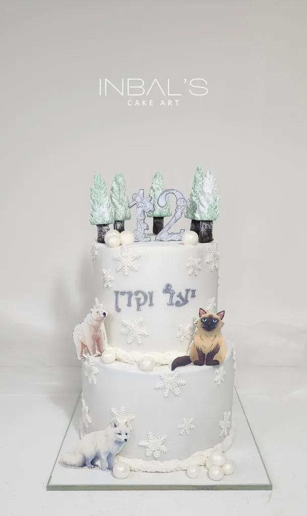 עוגת בת מצווה לבנה שתי קומות עם יער עם שלג למעלה וחתולים אכילים